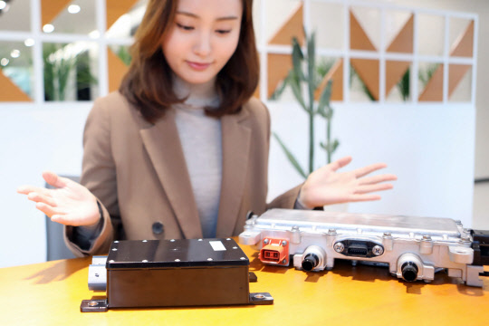 LG이노텍 직원이 GM에 공급 중인 EVCC(사진 왼쪽 제품)와 DC-DC 컨버터(사진 오른쪽 제품)를 선보이고 있다. <LG이노텍 제공>